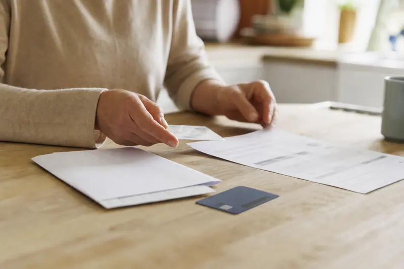 Mains organisant des documents administratifs pour ouvrir un compte bancaire.