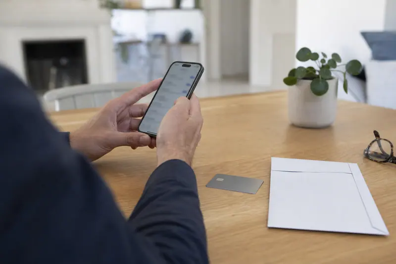 Smartphone et carte bancaire sur une table, pour gérer un compte en ligne.