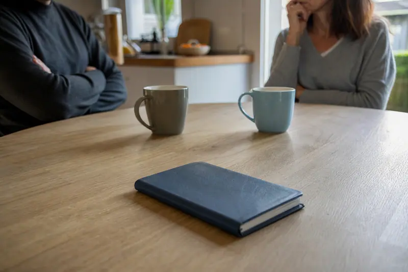 Chéquier fermé posé sur une table près de deux tasses de café
