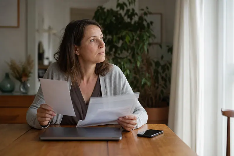 Femme préparant son dossier de prêt et ses documents à la maison