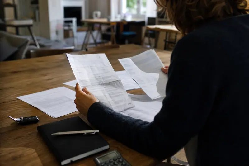 Documents d’assurance auto, clés de voiture et calculatrice sur une table.