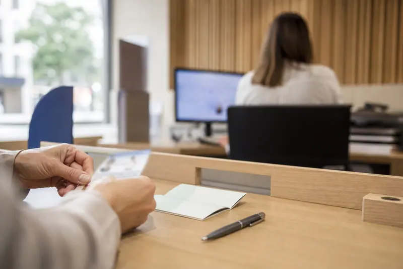 Dossier d’ouverture d’épargne posé sur une table dans un bureau de poste.