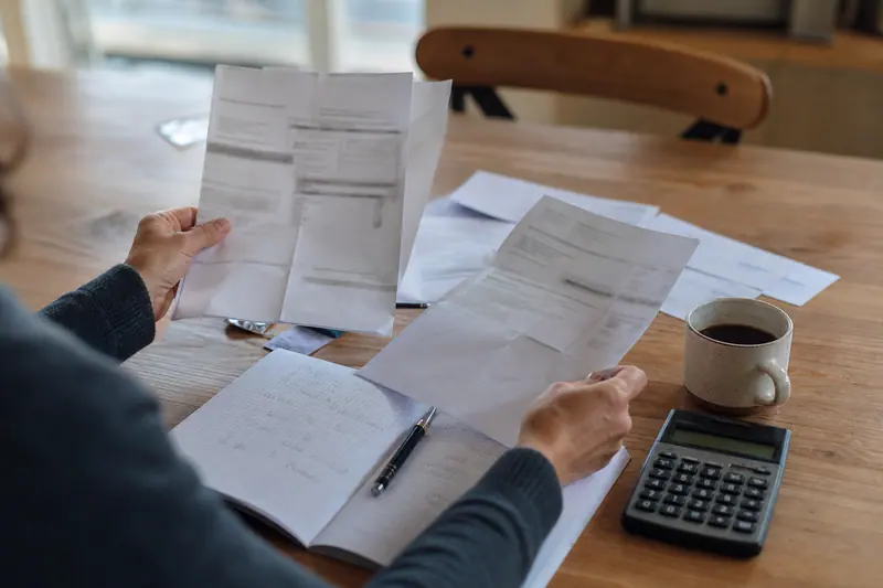 Calculatrice, carnet et documents bancaires pour comparer une offre d’épargne promotionnelle.