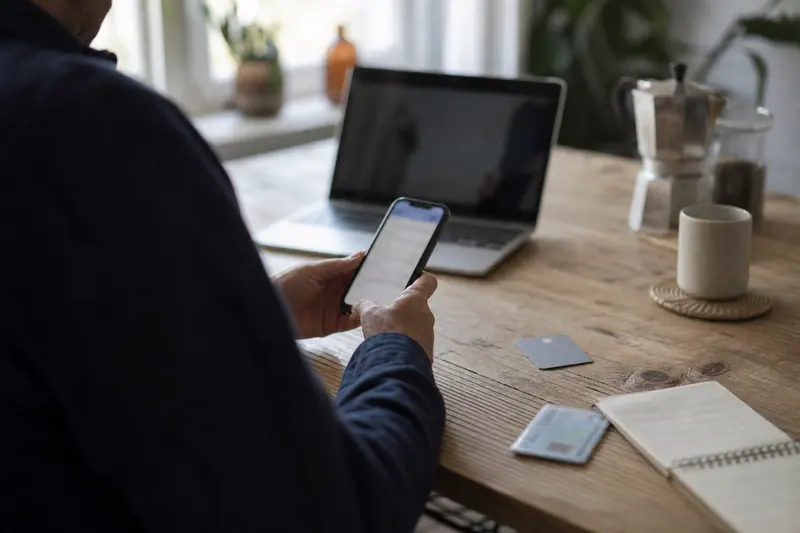Personne vérifiant les documents d’ouverture d’un compte bancaire sur smartphone.