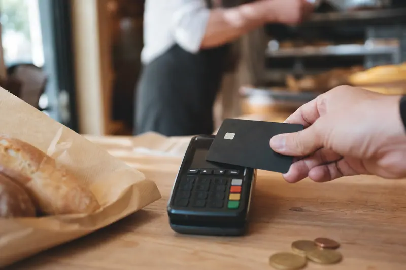 Paiement sans contact par carte sur un terminal dans un commerce français.